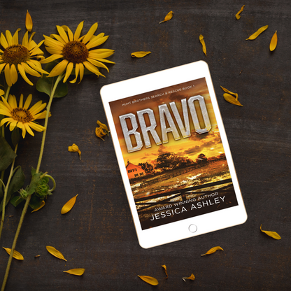 Tablet displaying the book 'Bravo' by Jessica Ashley with sunflowers on a dark surface